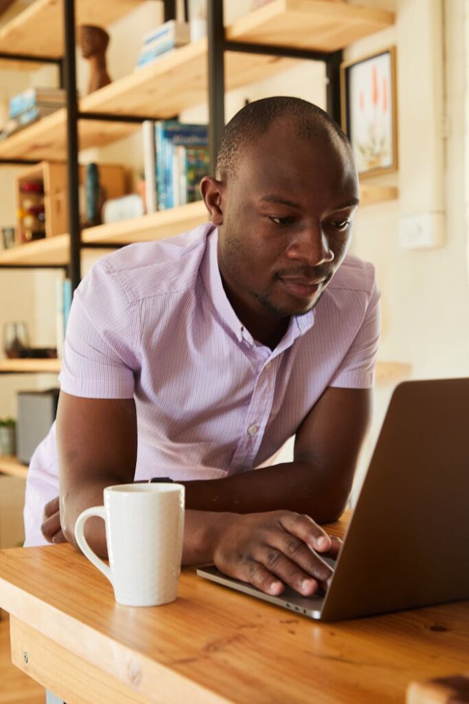 The Art of Drawing Readers In: Your attractive post title goes here Young African American male in shirt sitting at table with netbook and cup of beverage while working at home